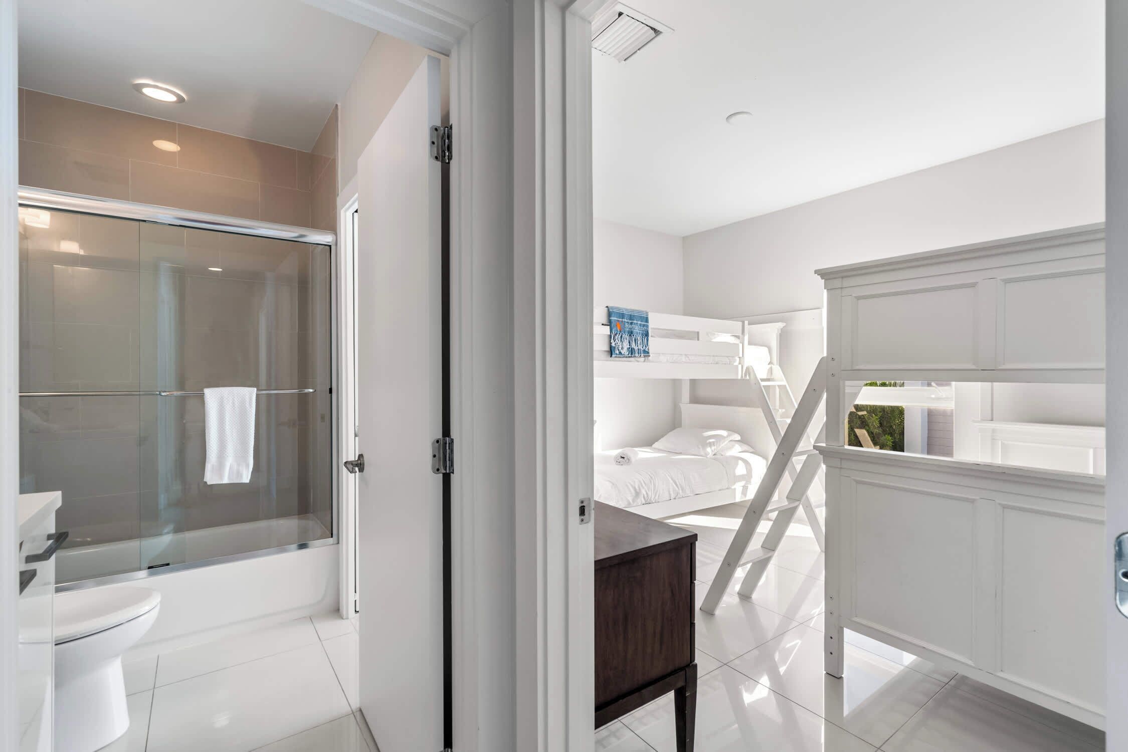 A modern bathroom with a glass-enclosed shower, a white toilet, and a vanity.