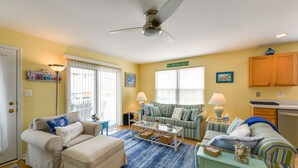 A living room with a sofa set, a coffee table, and a dining area. - Condo w/ Deck: Walk to Beach & Convention Center! (Wildwood)