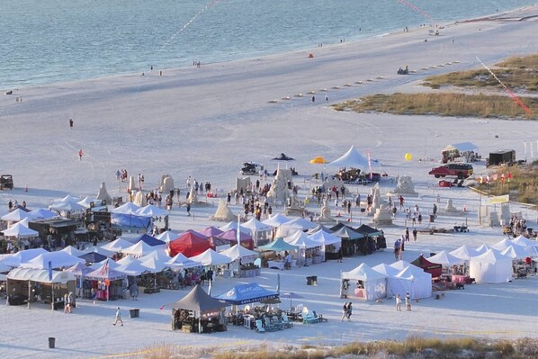 A beach with tents and people, likely a market or event.