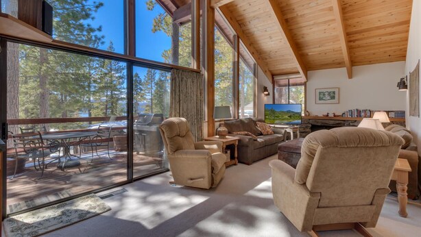 A spacious living room with large windows, a fireplace, and a cozy seating area.