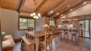 A spacious kitchen with wooden cabinets, stainless steel appliances, and a large island with bar stools.
