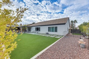 A modern house with a well-maintained lawn, a patio with outdoor furniture, and a gravel pathway leading to the entrance. - Desert Oasis Ranch-Style Mesa Home, Hiking/Tubing (Mesa)