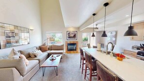 A modern living room with a sofa, coffee table, and dining area with chairs.