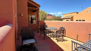 An outdoor patio with a grill, metal chairs, and a table. - Saddle Creek - 3A1, 3 Bedroom 2 and a Half Bath Condo (Moab)