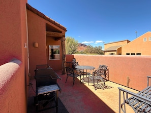An outdoor patio with a grill, metal chairs, and a table. - Saddle Creek - 3A1, 3 Bedroom 2 and a Half Bath Condo (Moab)