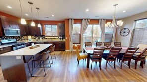 A modern kitchen with a central island, dining area with wooden chairs, and large windows. - Entrada at Moab - 640-Beautiful Condo Downtown Moab (Moab)