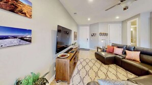 A modern living room with a flat-screen TV, a leather sofa, and a patterned rug. - Entrada at Moab - 668, Wolf Den (Moab)