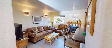 A cozy living room with a sofa, armchair, and a small table.
