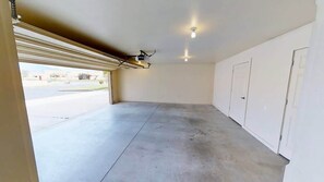 A garage with a concrete floor, a ceiling fan, and a light fixture.