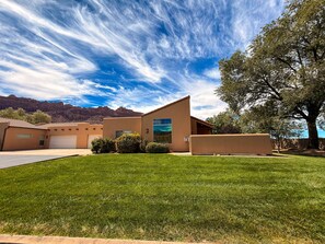 A modern house with a flat roof, a garage, and a well-maintained lawn.