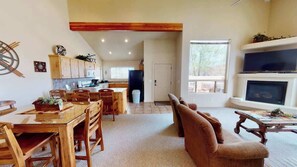 A spacious living area with a dining table, sofas, and a fireplace.