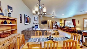 A spacious living area with a dining table, sofas, and a fireplace. - Arches West - 393, Townhome In Moab's most request (Moab)