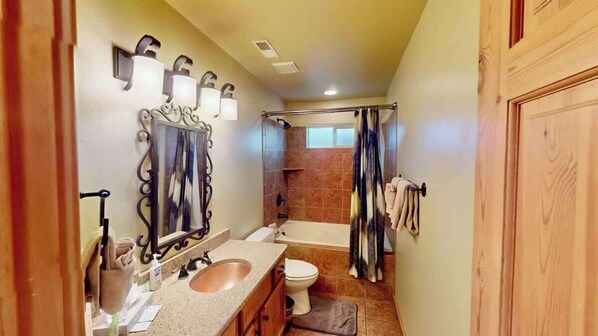 Un baño con lavamanos, inodoro y zona de ducha.