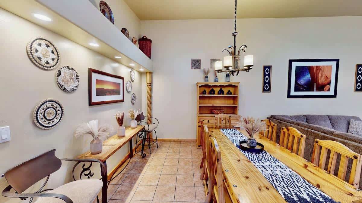 A dining area with a wooden table, chairs, and a chandelier.