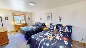 A bedroom with two beds, a dresser, a window, and wall decorations. - The Rock - 3461 (Moab)