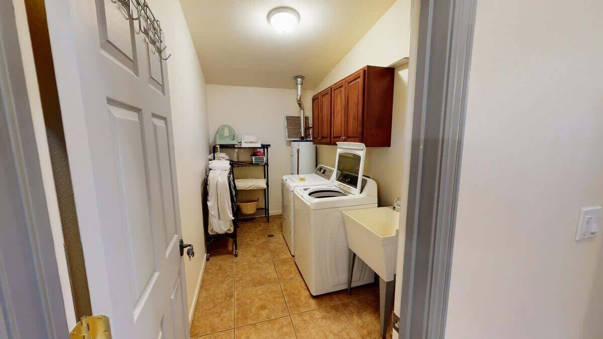 A laundry room with a washing machine, dryer, and a sink.