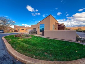 A modern two-story house with a flat roof, a well-maintained lawn, and a clear blue sky. - Jan's Joy - N3, Southwestern Flair, Pet Friendly C (Moab)