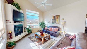A living room with a fireplace, a television, a sofa, and a coffee table.