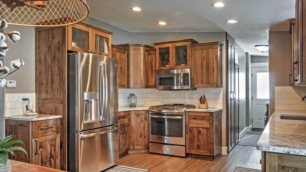 A modern kitchen with wooden cabinets, stainless steel appliances, and a central island. - Rustic Chic Home: 10 Mi to Otter Creek State Park! (Kingston)