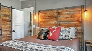 A bedroom with a wooden headboard, a bed with patterned bedding, and a ceiling fan. - Rustic Chic Home: 10 Mi to Otter Creek State Park! (Kingston)