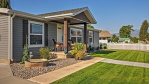 A two-story house with a covered porch, a front yard with a lawn and a small garden, and a white picket fence. - Rustic Chic Home: 10 Mi to Otter Creek State Park! (Kingston)