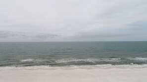 A beach with a wide sandy shore and calm ocean waves.