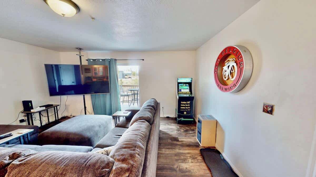 A living room with a sofa, a flat-screen TV, and a wall-mounted bike emblem.