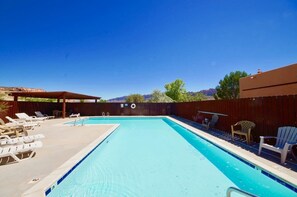 A rectangular swimming pool with a wooden deck and lounge chairs on one side. - Castle View - 3368, 3 Bed 2 Bath Town Home On Moab (Moab)