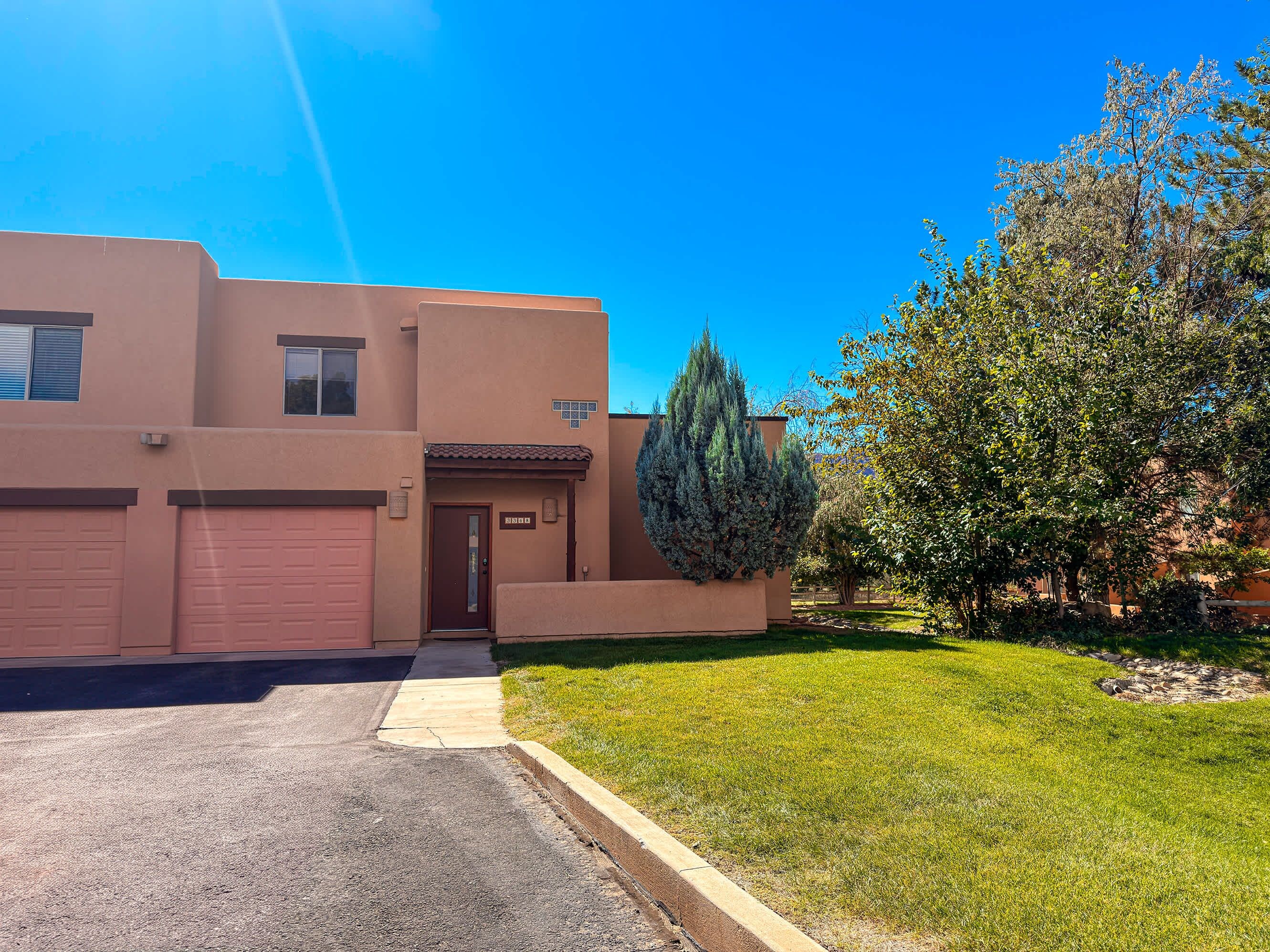 A residential building with a garage, a front door, and a well-maintained lawn.