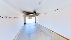 A parking garage with a concrete floor, a metal roof, and a visible exit. - Castle View - 3368, 3 Bed 2 Bath Town Home On Moab (Moab)