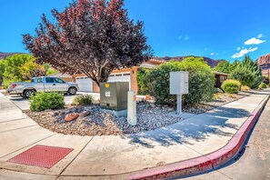 Stroll through a serene suburban neighborhood with a well-manicured lawn and a large tree.