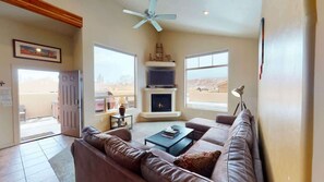 A living room with a fireplace, a sofa, a coffee table, and a television. - Desert Oasis - X1, Private Hot Tub, Pet Friendly (Moab)