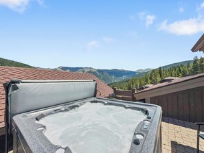 Un jacuzzi en una azotea con vistas a la montaña.