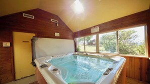 Un jacuzzi en una cabaña de madera con vista al exterior.