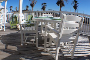 A wooden deck with white chairs and a table, surrounded by a white railing. - Beach Front, dog friendly, 20 steps to Beach! (Cape San Blas)