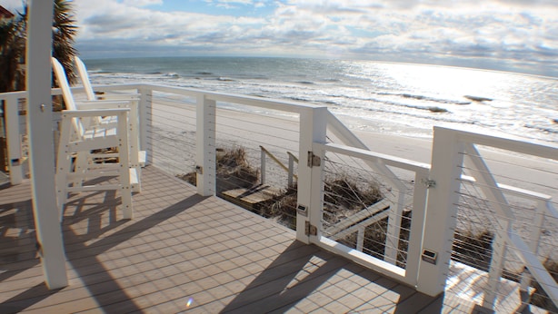 A wooden deck with a white railing overlooking the beach. - Beach Front, dog friendly, 20 steps to Beach! (Cape San Blas)