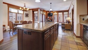 Una cocina amplia con una isla grande, armarios de madera y horno empotrado.