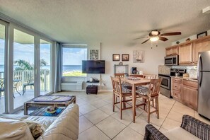 Une cuisine moderne avec un coin repas, un ventilateur de plafond et une vue sur la plage.