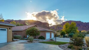 A residential area with houses, a driveway, and a mountain in the background. - Home Downtown | Indoor Pool | Fenced Backyard (Moab)