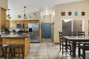 Enjoy meals in the kitchen with a central island, sink, and dining area with a large table and chairs.