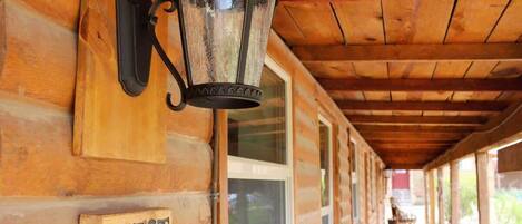 A wooden exterior wall with a sign labeled 'WEST' and a black lantern fixture.