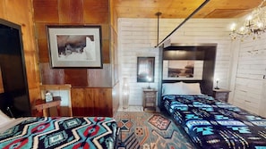 A room with a bed, a desk, and a chair. There is a framed picture on the wall. - Pack Creek - The Lodge (Moab)