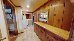 A kitchen with wooden cabinets, a countertop, and a refrigerator. - Pack Creek - The Lodge (Moab)