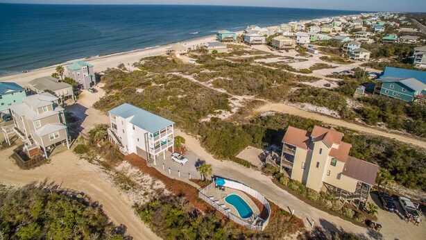 An aerial view of a coastal residential area with houses, a beach, and a swimming pool. - La Bella Vita- Beautiful views of the gulf with private pool! (Port St Joe)
