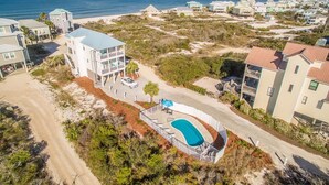 An aerial view of a coastal residential area with houses, a swimming pool, and a beach. - La Bella Vita- Beautiful views of the gulf with private pool! (Port St Joe)