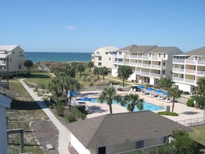 A hotel with a pool area, multiple balconies, and a view of the ocean. - 4bdrm Townhome on N CSB (Cape San Blas)
