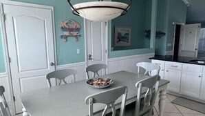 Spisebord med fire stole, en skål med frugt og en pendel over.