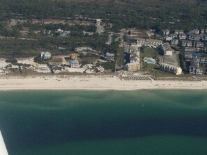 An aerial view of a coastal area with a beach, buildings, and a large hotel complex. - 4bdrm Townhome on N CSB (Cape San Blas)
