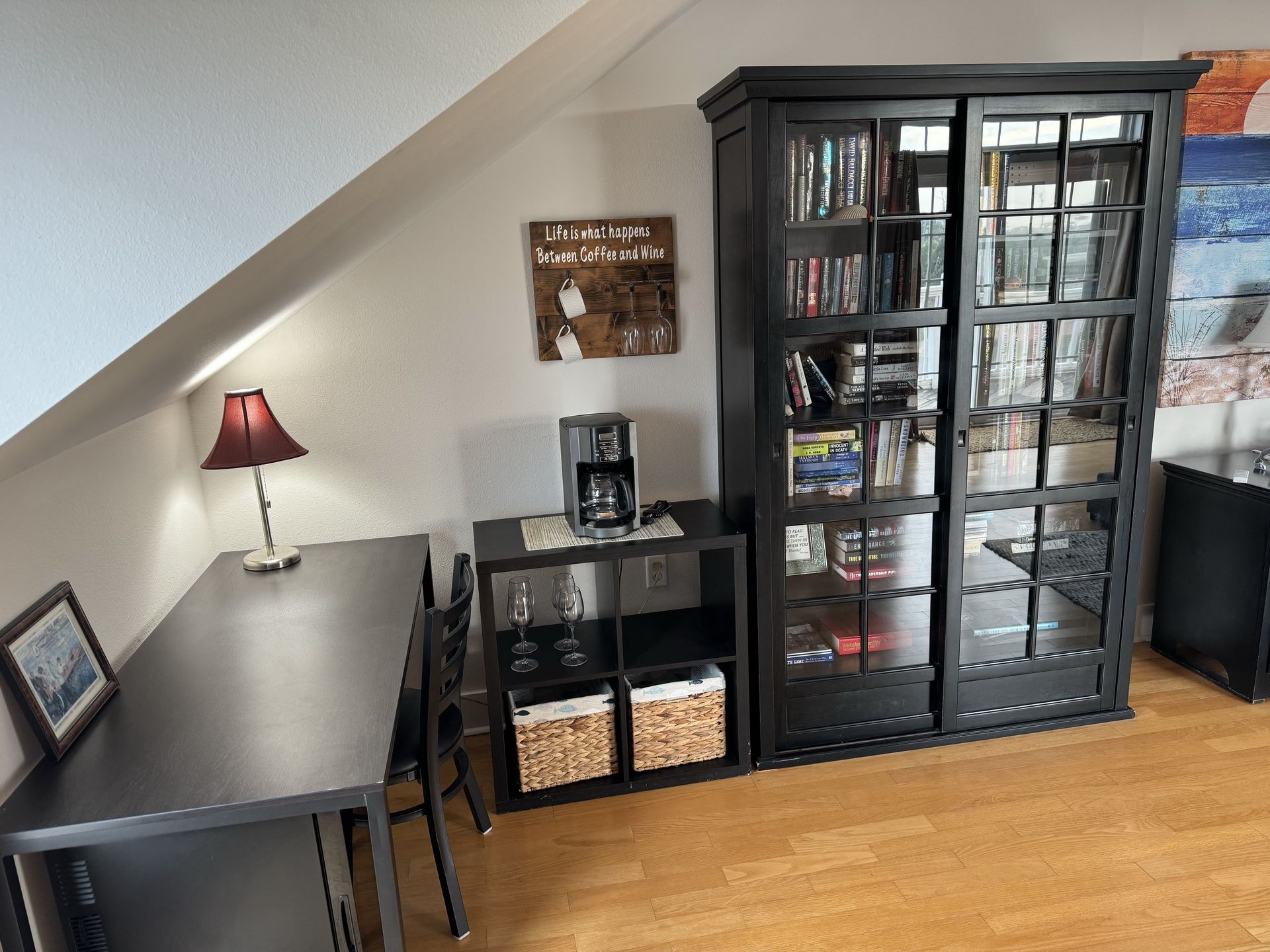 Eine gemütliche Leseecke mit Bücherregal, einer Kaffeemaschine und einer Lampe.