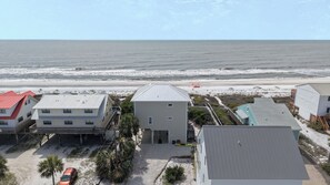 A coastal residential area with houses, a beach, and the ocean.